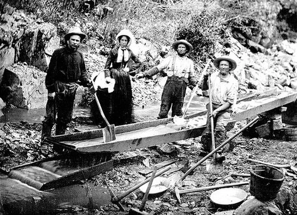 Daguerreotype of a woman and men working a sluice at a California gold claim around 1850